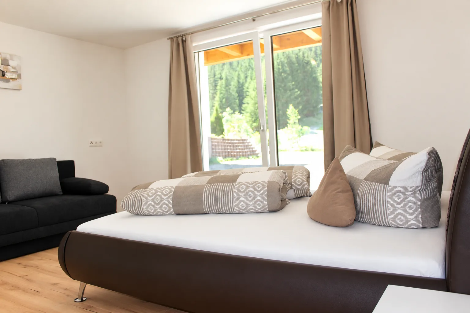 Schlafzimmer mit Doppelbett und Sofa im Apartment Apart Alpenjuwel
