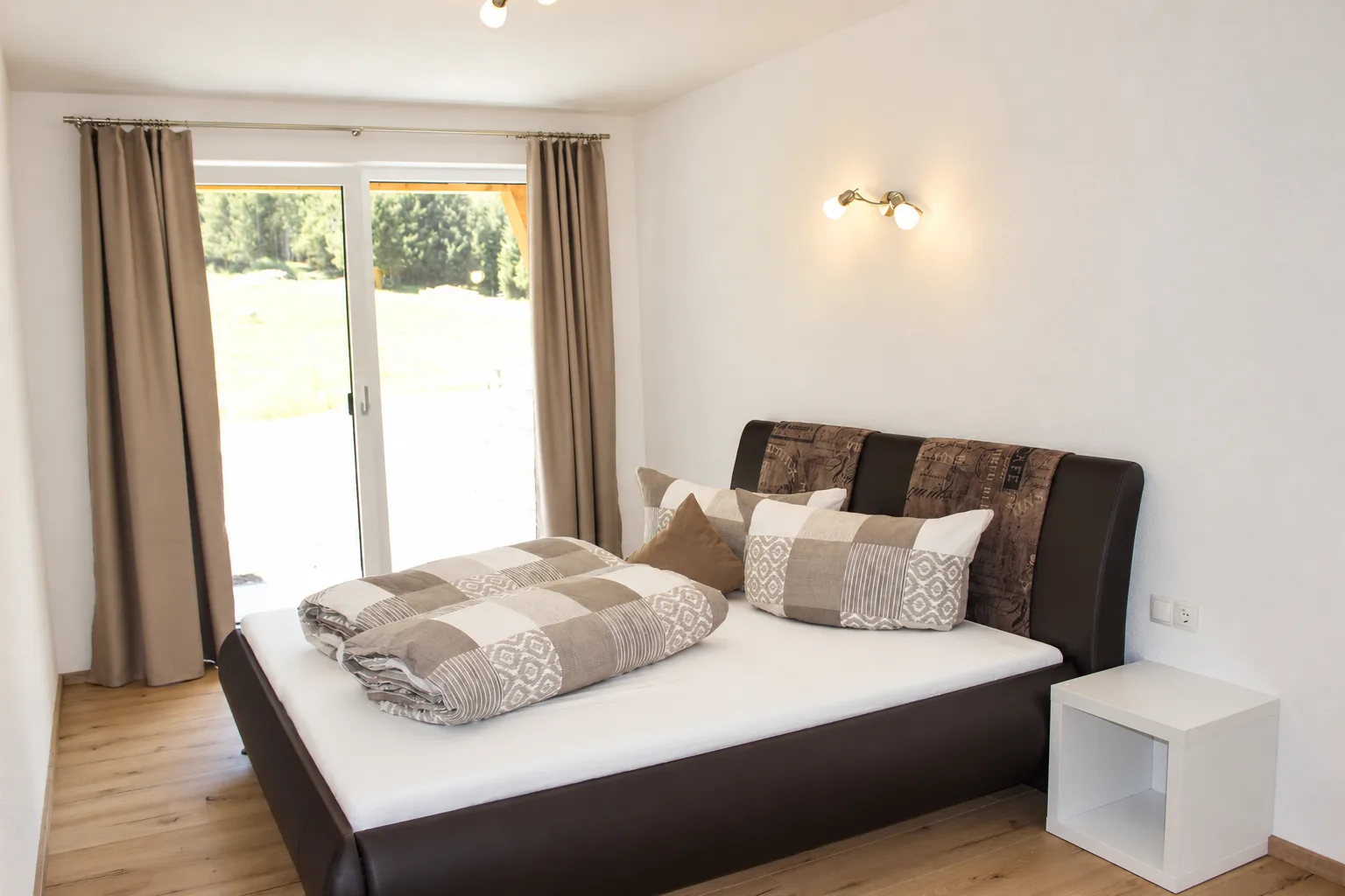 Schlafzimmer mit Doppelbett und Terrassentuer im Apartment Apart Alpenjuwel